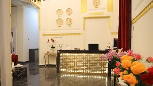 A hotel reception area with a reception desk, clocks displaying times from New York, London, Tokyo, and Sao Paulo, and a tour desk. - Palace Court (Cairo)