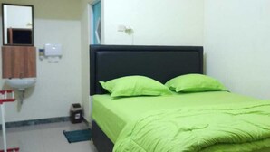 Un dormitorio con cama, espejo, lavamanos y aire acondicionado.
