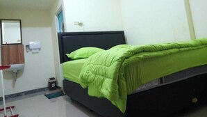 Una habitación con una cama, un lavabo y un espejo.