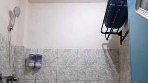 Un baño con baldosas estampadas, una ducha y una puerta con un perchero para toallas arriba.