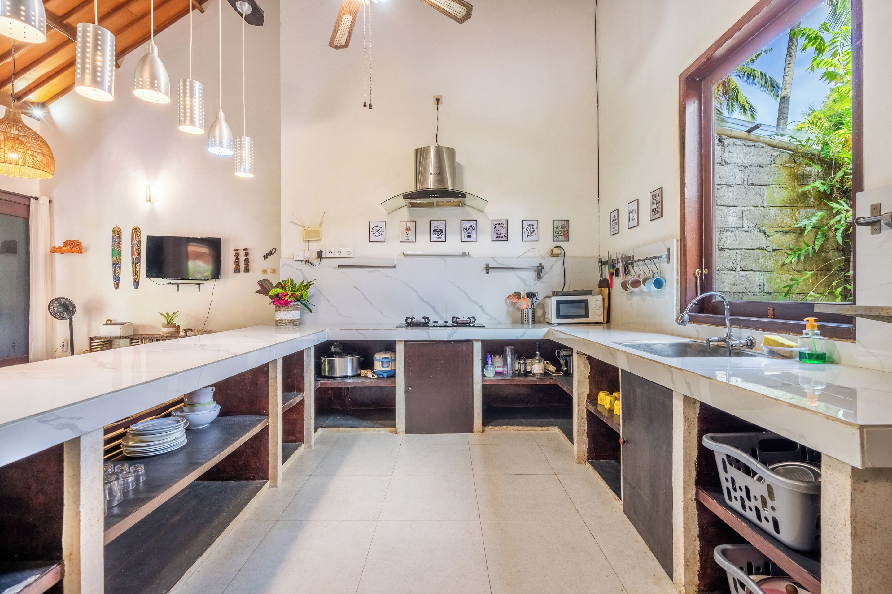 Una cocina moderna con una isla central, electrodomésticos integrados y vistas a zonas verdes.
