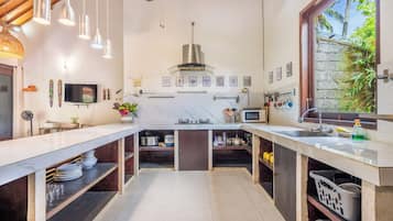 Una cocina moderna con una isla central, electrodomésticos integrados y vistas a zonas verdes.