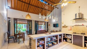 Cocina amplia con una isla grande, techo de madera, lámparas colgantes y estufa integrada.