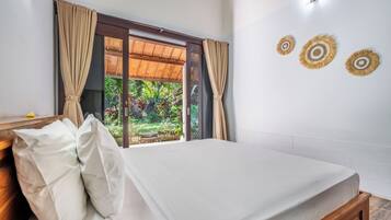 Ein Schlafzimmer mit Bett, Vorhängen, einem Fenster und Wanddekoration.