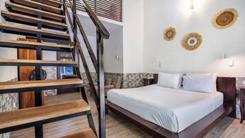 Un dormitorio con escalera de madera, cama con ropa de cama blanca y decoración mural.