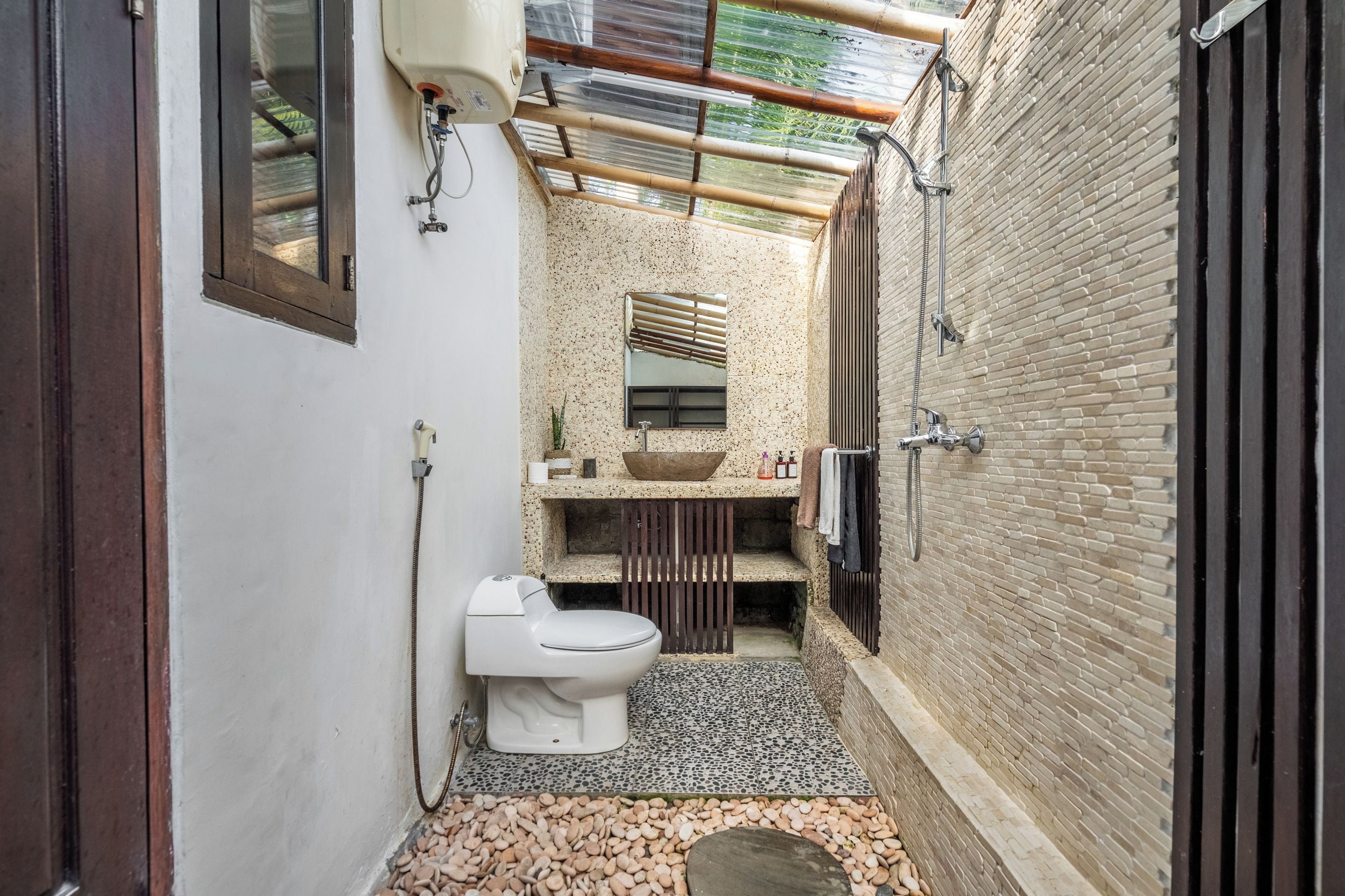 Un baño pequeño con inodoro, lavamanos y ducha.