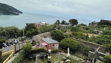 A coastal property with a patio area, outdoor seating, and a view of the sea.