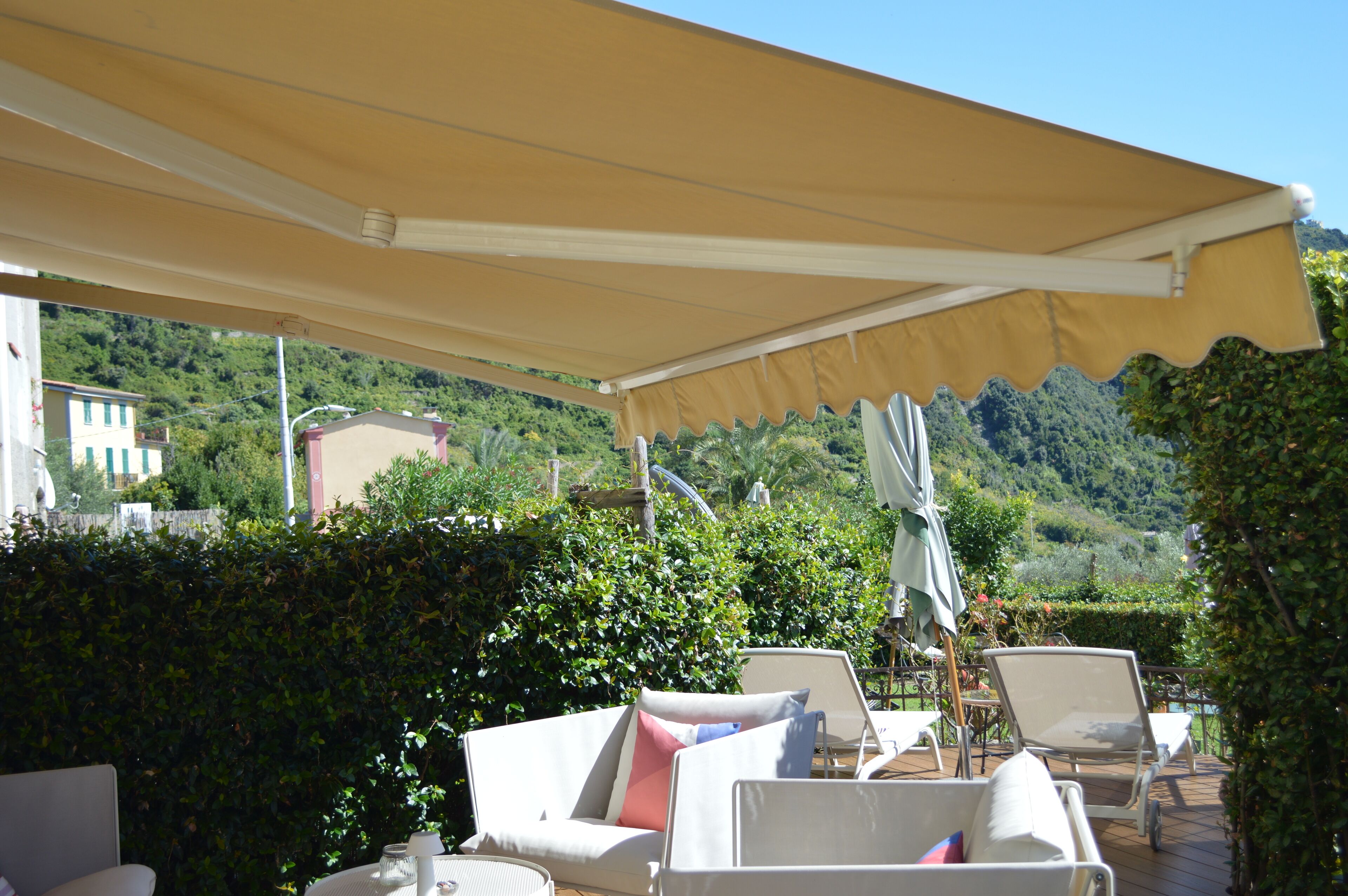 An outdoor patio with a canopy, lounge chairs, and a table.