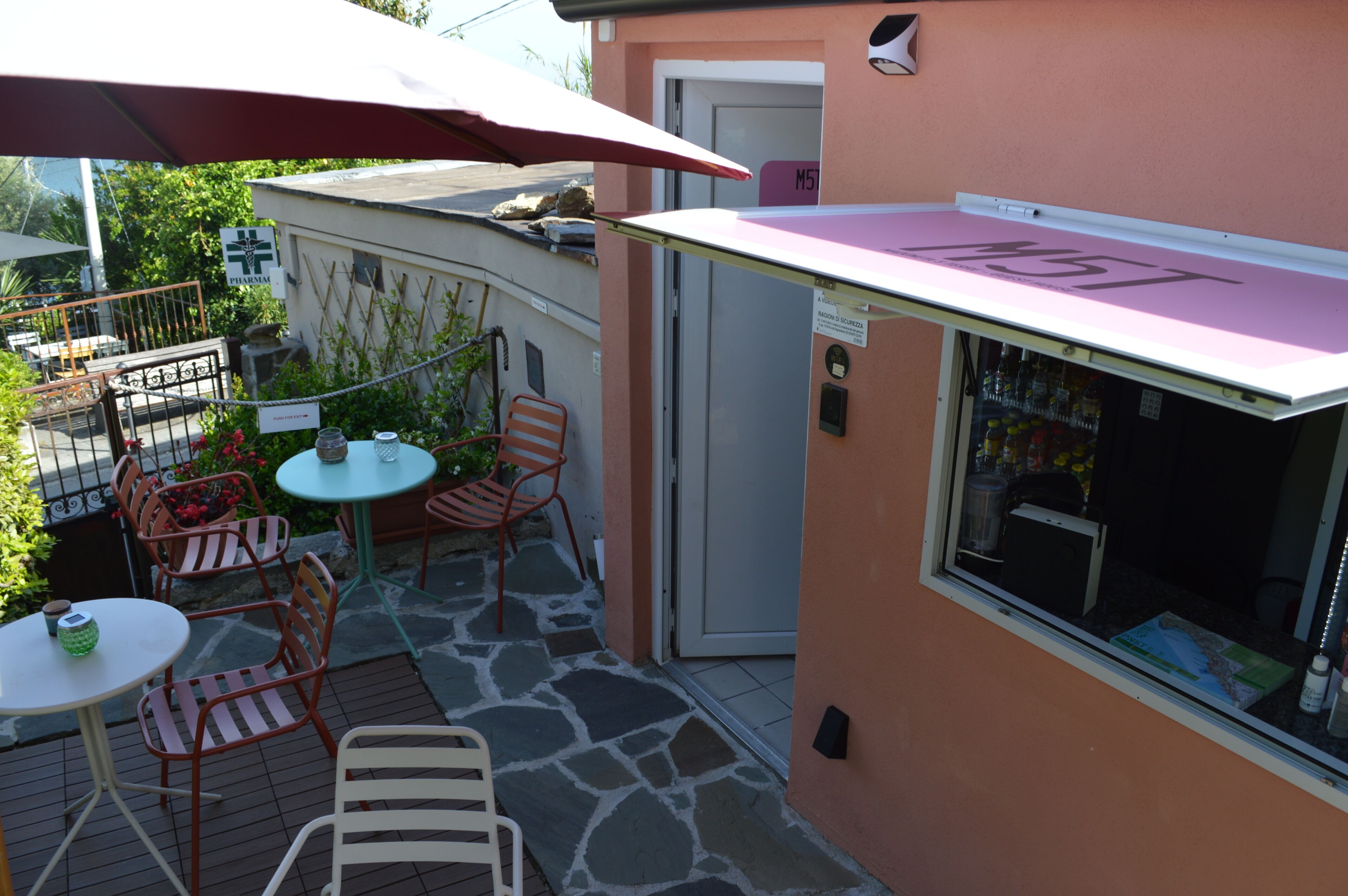 A patio area with outdoor seating, a small table, and a refrigerator.