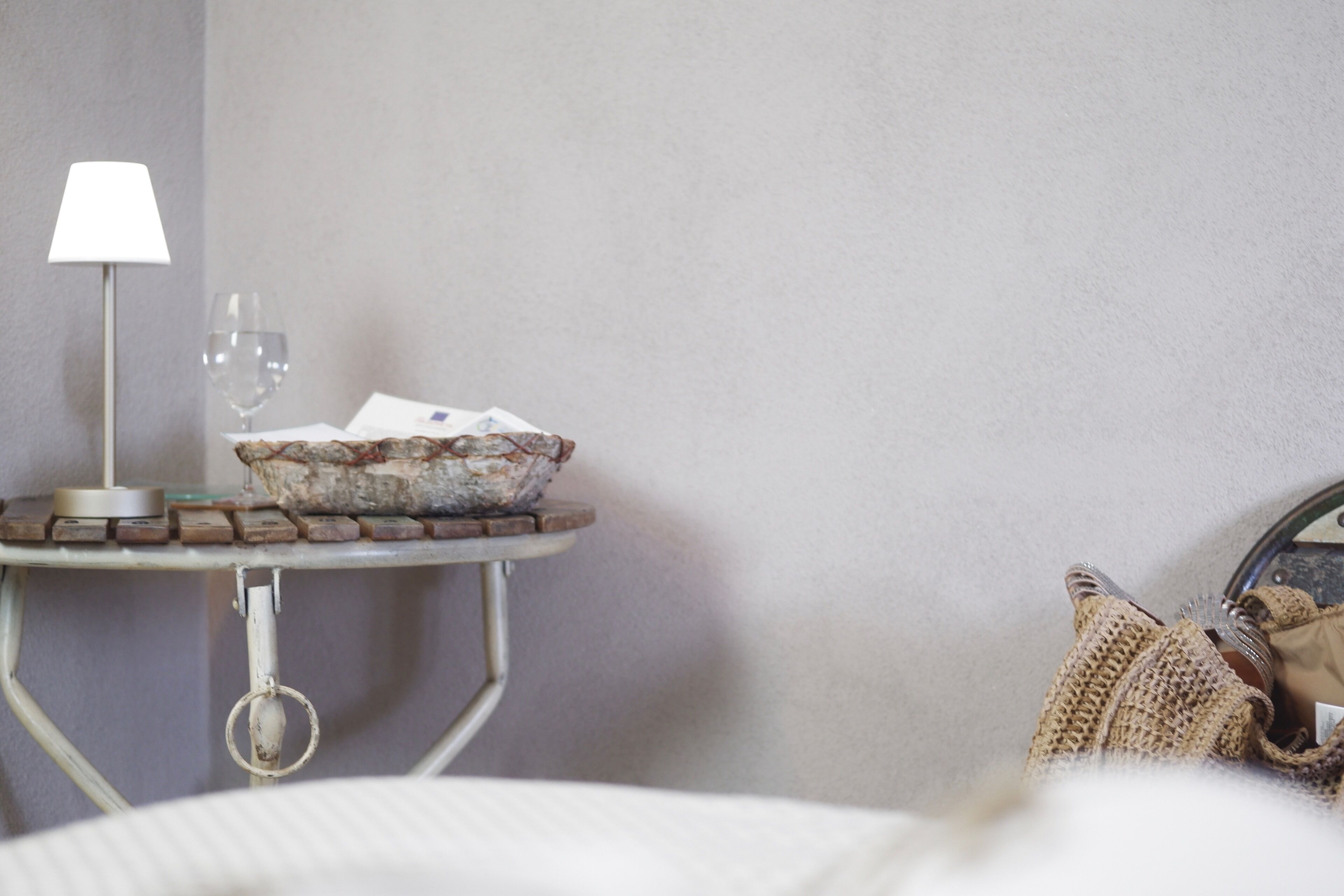 A small table with a lamp, a glass of water, and a bowl of keys.