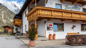 A building with a balcony, a sign reading 'Bergkristall,' and a mountain in the background.