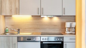 Eine moderne Küche mit Edelstahlgeräten, Holzschränken und einer Kaffeemaschine.