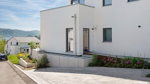 Ein modernes, zweistöckiges Gebäude mit flachem Dach, einem gut sichtbaren Eingang und einer gepflasterten Auffahrt.