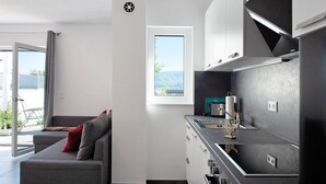 Eine moderne Küche mit grauer Arbeitsplatte, Edelstahlgeräten und einem Fenster mit Blick auf die Berge.