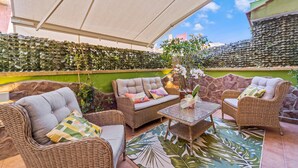An outdoor patio with wicker furniture, a table, and a decorative plant. - Holiday Home "Ca' Alessandra" with Private Terrace and Air Conditioning (Carloforte)