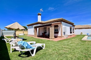 A house with a patio, outdoor seating, and a swimming pool.