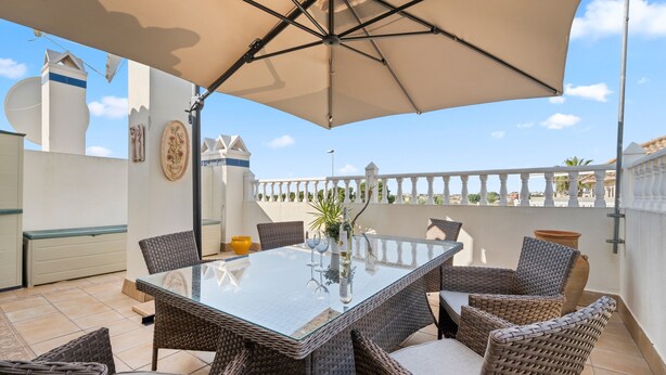 An outdoor patio with a glass-top table, wicker chairs, and a large umbrella. - Holiday Home "Un Regalo de Corazón" with Shared Pool & Wi-Fi (Orihuela)