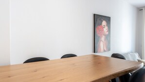 A conference room with a wooden table, black chairs, and a painting on the wall. - Apartment 'Apartamento Postal' with Balcony, Wi-Fi and Air Conditioning (Fuengirola)