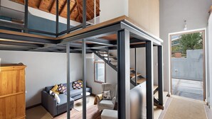 Een modern interieur met een loft-achtige zoldervloer, een trap, een bank en een houten kast.