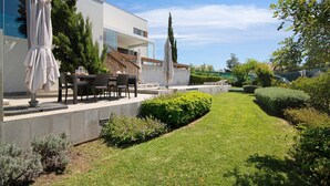 A modern house with a patio, outdoor furniture, and a well-maintained lawn. - Villa "Sweet Home Albufeira" with Private Pool, 2 Private Terraces & Wi-Fi (Albufeira)