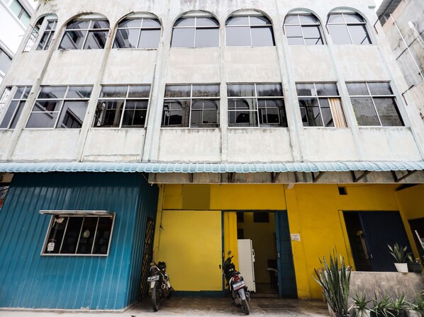 A building with multiple windows and a yellow entrance.