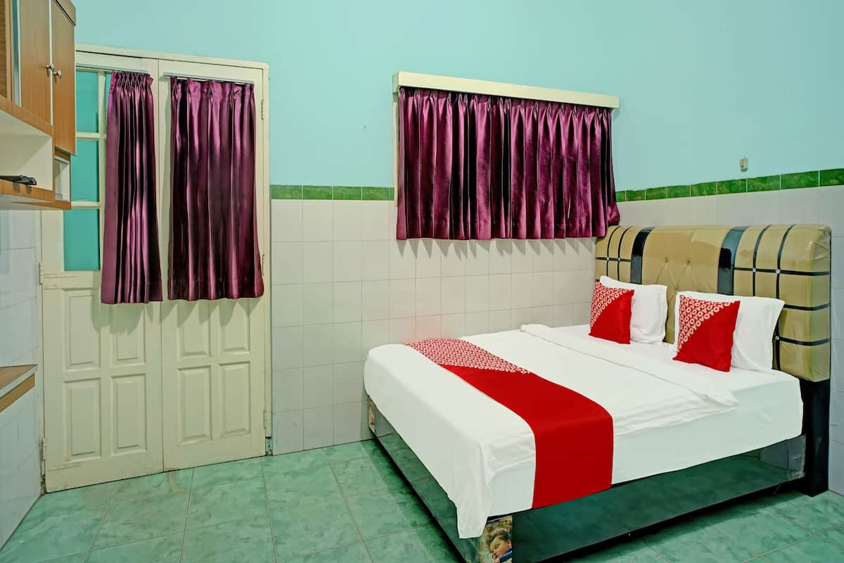 Une chambre à coucher avec un lit, des rideaux, une armoire et un sol carrelé.