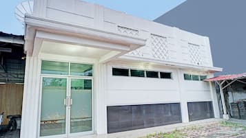 A modern building with a garage, large glass doors, and a tiled entrance area.