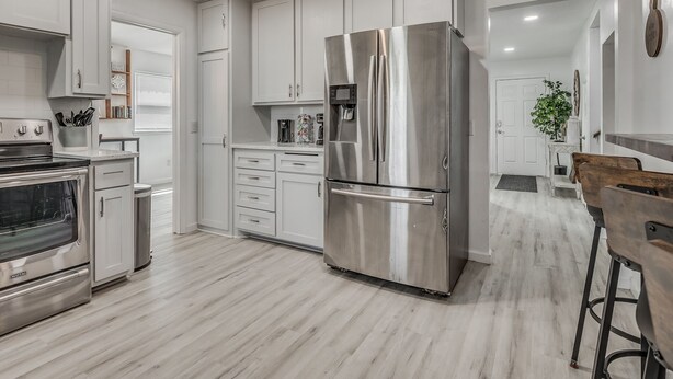 A modern kitchen with white cabinetry, a stainless steel refrigerator, a built-in oven, and a microwave. - Capital View - Downtown OKC 7 MINS AWAY (Oklahoma City)