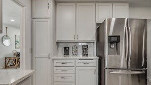 A modern kitchen with white cabinets, a stainless steel refrigerator, and a coffee maker on the countertop. - Capital View - Downtown OKC 7 MINS AWAY (Oklahoma City)