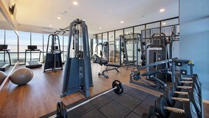 A modern gym with cardio equipment, weightlifting stations, and a view of the outdoors.