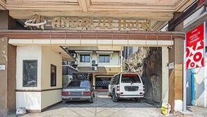 The entrance to Andalus Hotel with two parked cars, a signboard, and a building facade. - OYO Life 90380 Andalus Hotel Syariah (Surabaya)