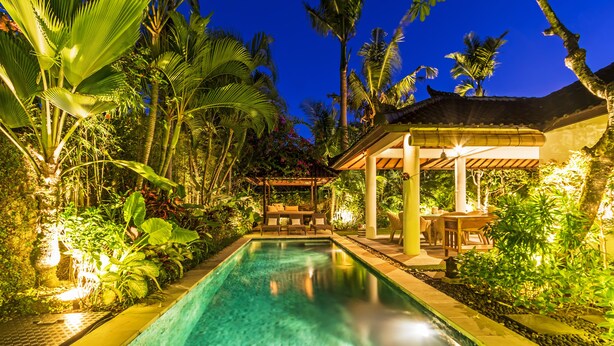 A swimming pool surrounded by lush greenery and a gazebo. - Baliani Beauty (Seminyak)