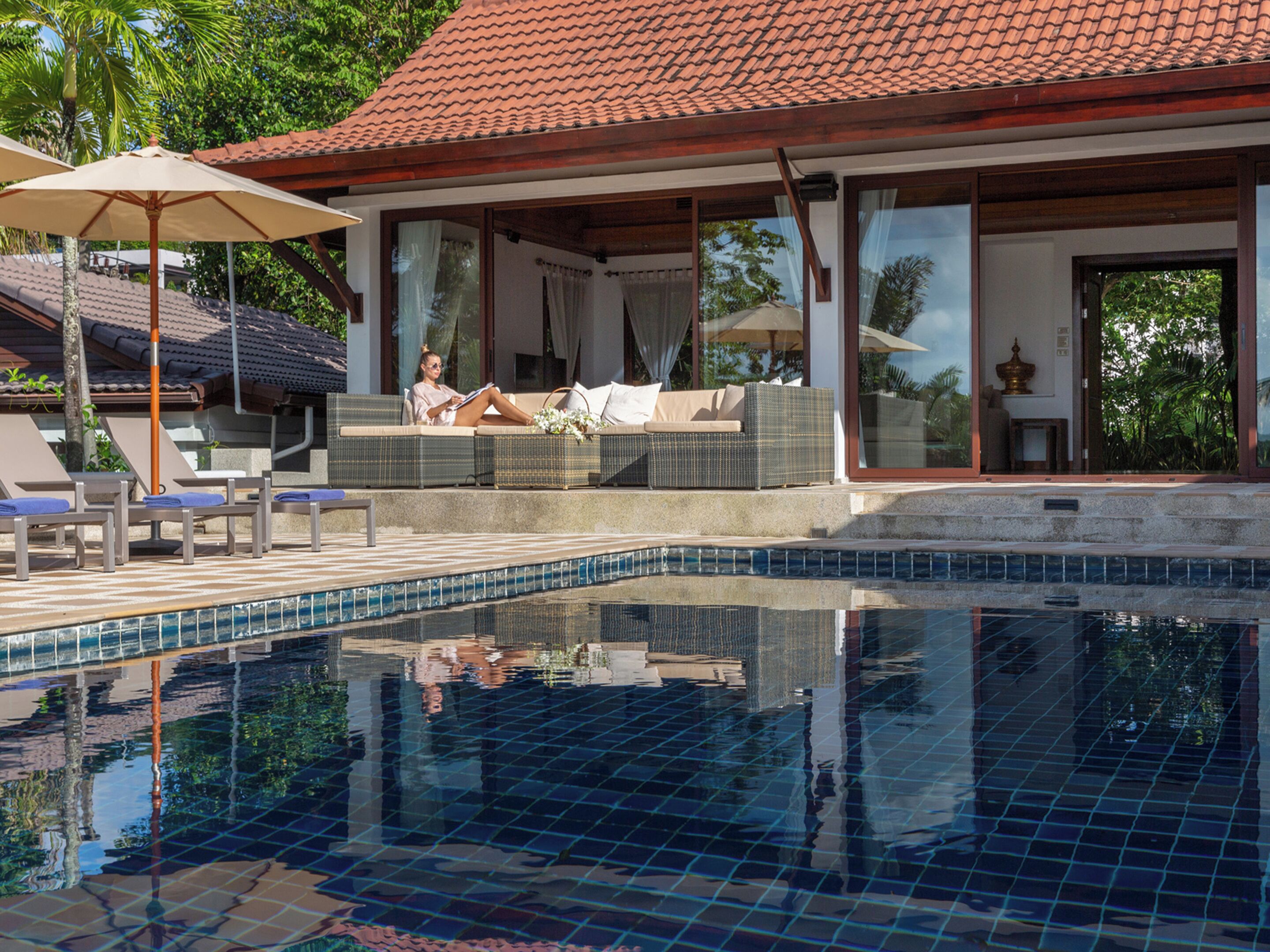 A poolside area with lounge chairs, a covered seating area, and a clear view of the pool.
