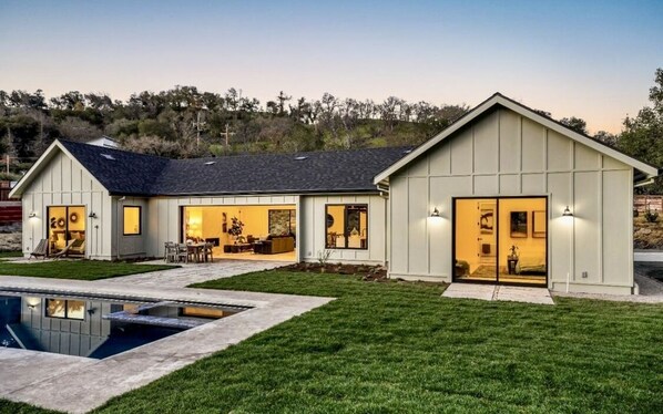 Enjoy a spacious living area and separate bedroom, with a serene outdoor space featuring a lawn and swimming pool.