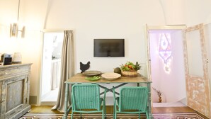 Un comedor con una mesa, sillas, un televisor y una cesta decorativa.