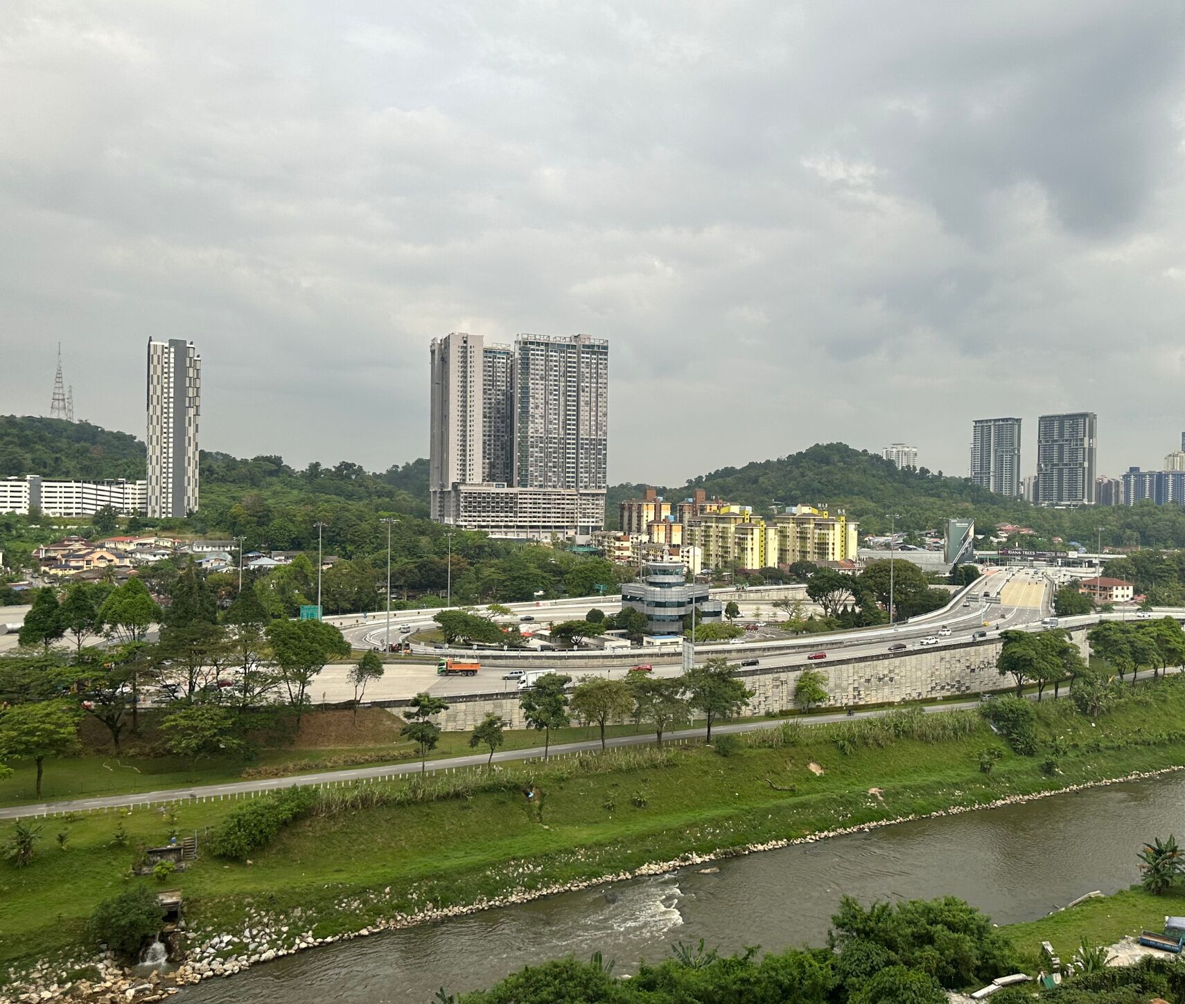 A cityscape with high-rise buildings, a river, and a bridge.