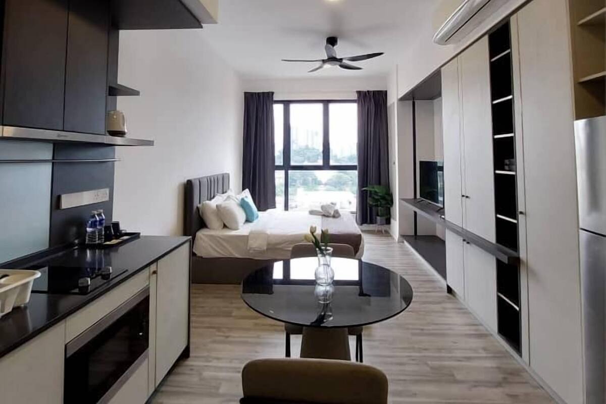 Una cocina moderna con comedor, cama y vistas al exterior.