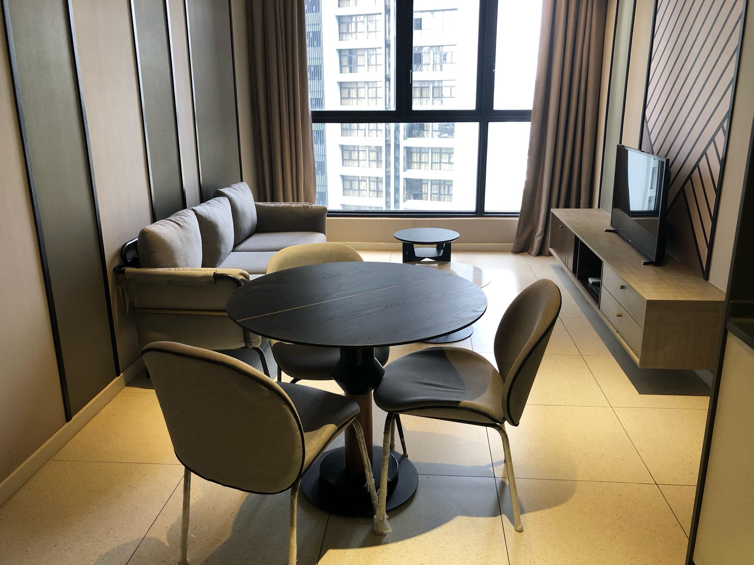 A modern living room with a sofa, a round table, and chairs.