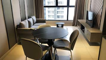 A modern living room with a sofa, a round table, and chairs.