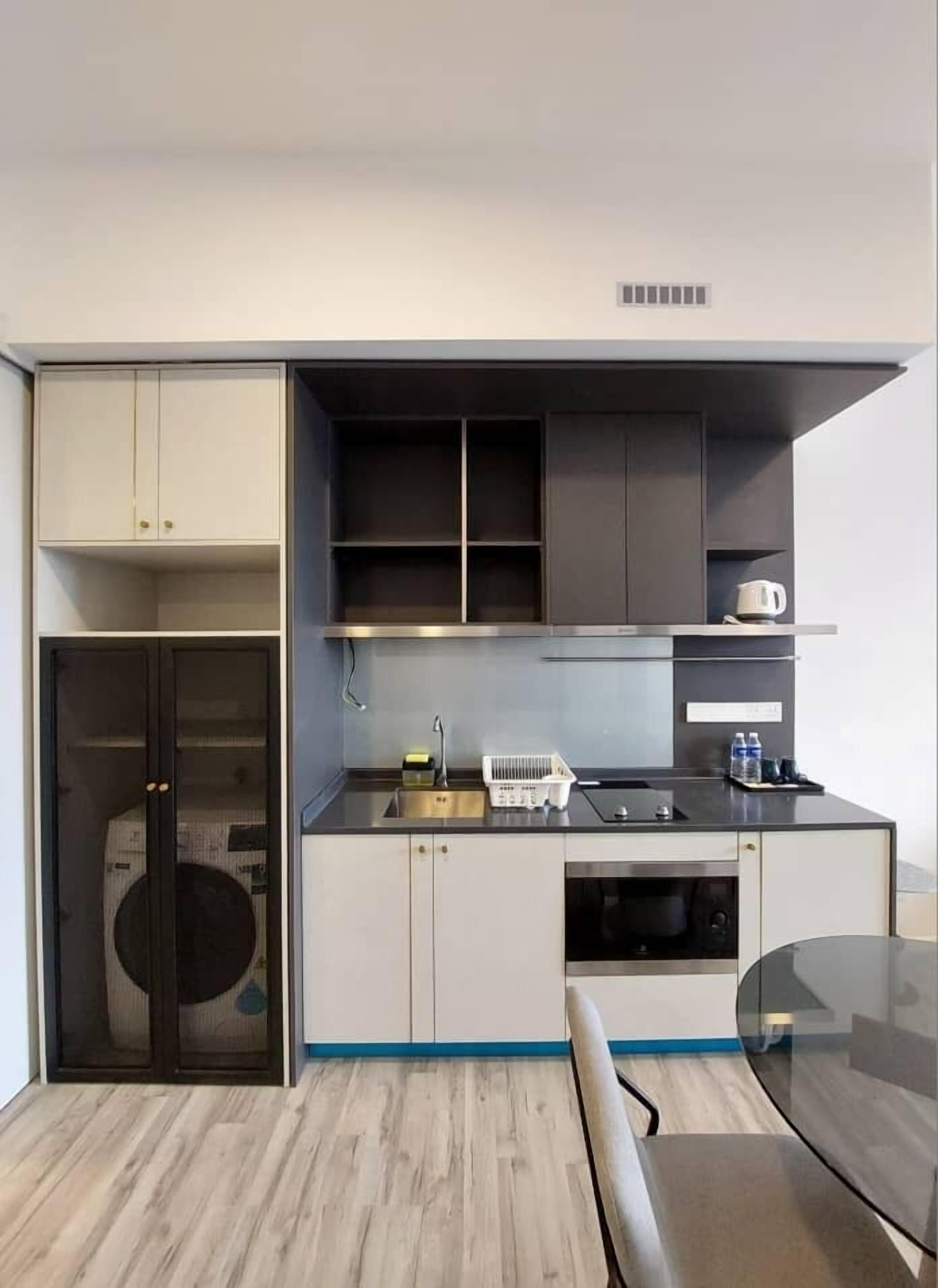 A compact kitchen with a sink, stove, and storage cabinets.