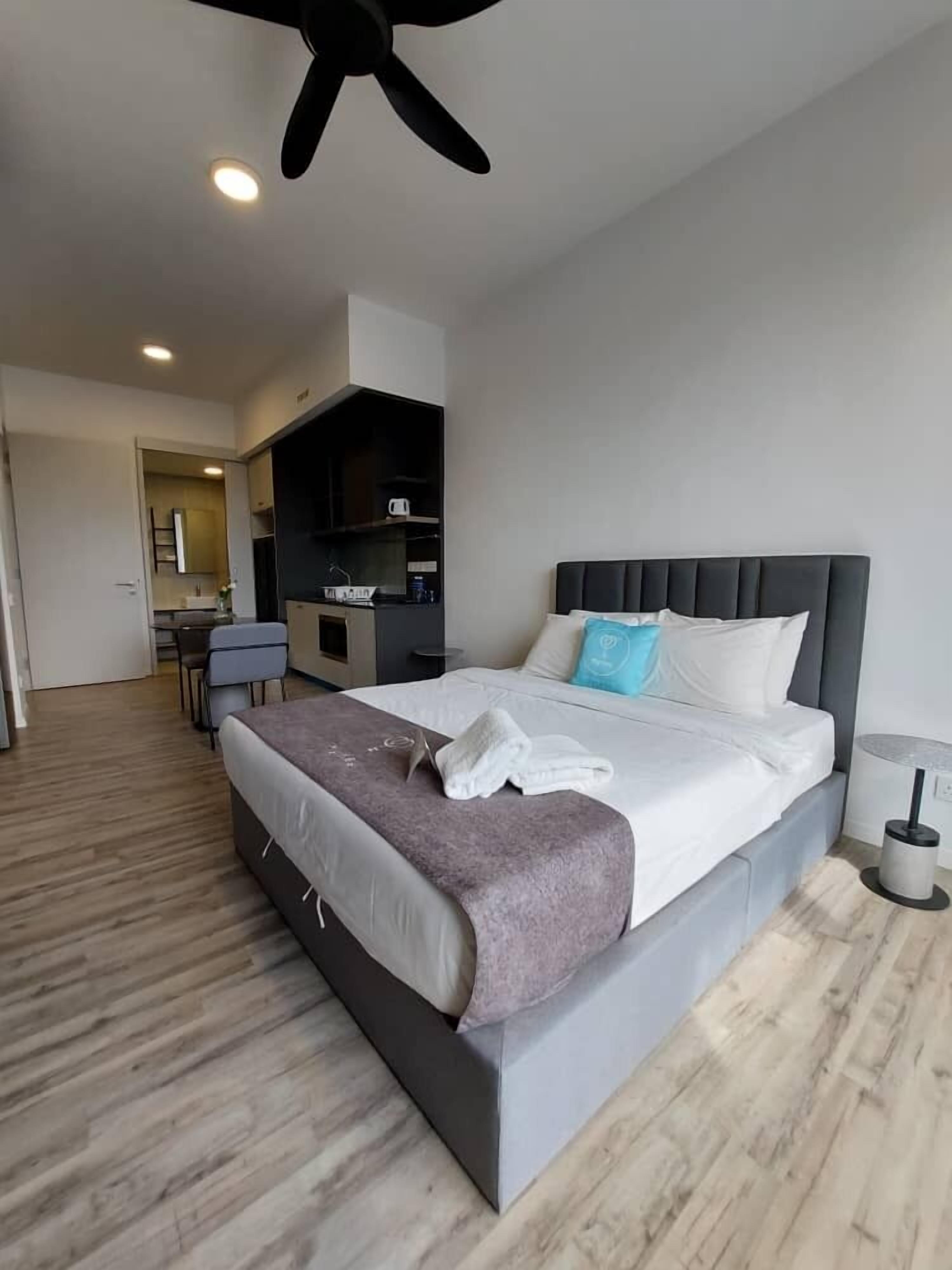 Een moderne hotelkamer met een groot bed, een bureau en een kitchenette.
