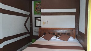Un dormitorio con cama, cabecero de madera, baldosas de suelo estampadas y un ventilador de techo.