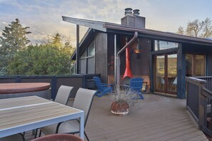 Eine Terrasse mit Tisch und Stühlen, ein roter Sessel und ein Blumentopf.