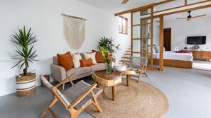 Uma sala de estar moderna com um sofá, cadeiras, uma mesa de centro e uma janela grande.