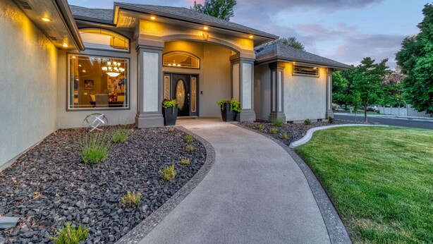 A modern house with a curved driveway, a well-maintained lawn, and a landscaped front yard with rocks and plants. - Welcome to The Greentree Retreat (Walla Walla)