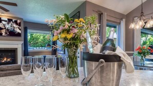 A kitchen counter with a vase of flowers, a wine bucket, and several wine glasses. - Welcome to The Greentree Retreat (Walla Walla)