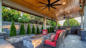 An outdoor patio with a fire pit, seating, and a stone fireplace. - Welcome to The Greentree Retreat (Walla Walla)