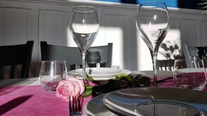 A dining table set with plates, glasses, and a rose. - Chateau de la Rose (Cluis)