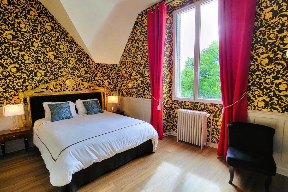 Quarto com uma cama grande, uma cadeira, um radiador e uma janela com cortinas.
