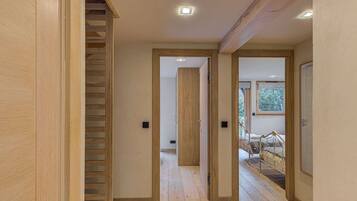 Een modern interieur met houten vloeren, een trap en een bed met uitzicht op bomen.